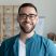 Close up headshot portrait of smiling young Caucasian businessman in glasses posing in office. Profile picture of happy millennial male employee or worker in eyewear at workplace. Employment concept.